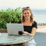 Digital nomad working on laptop with Tamarindo beach sunset Costa Rica 2026